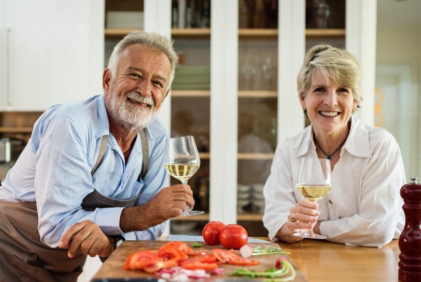 man and woman in kitchen holding glasses of wine