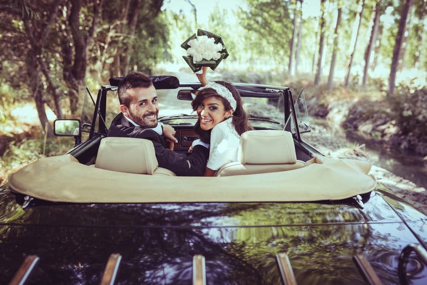 Just married couple together in an old car