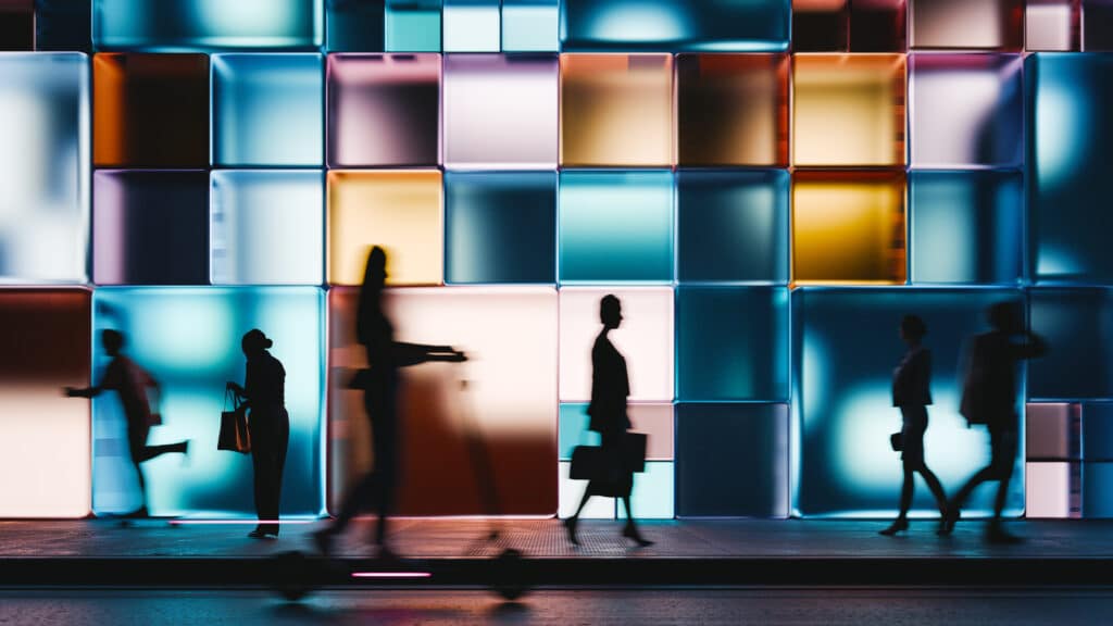 people walking in front of colorful cubes