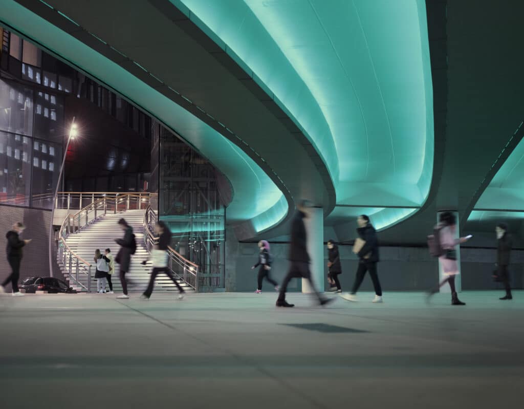people under green light underpass