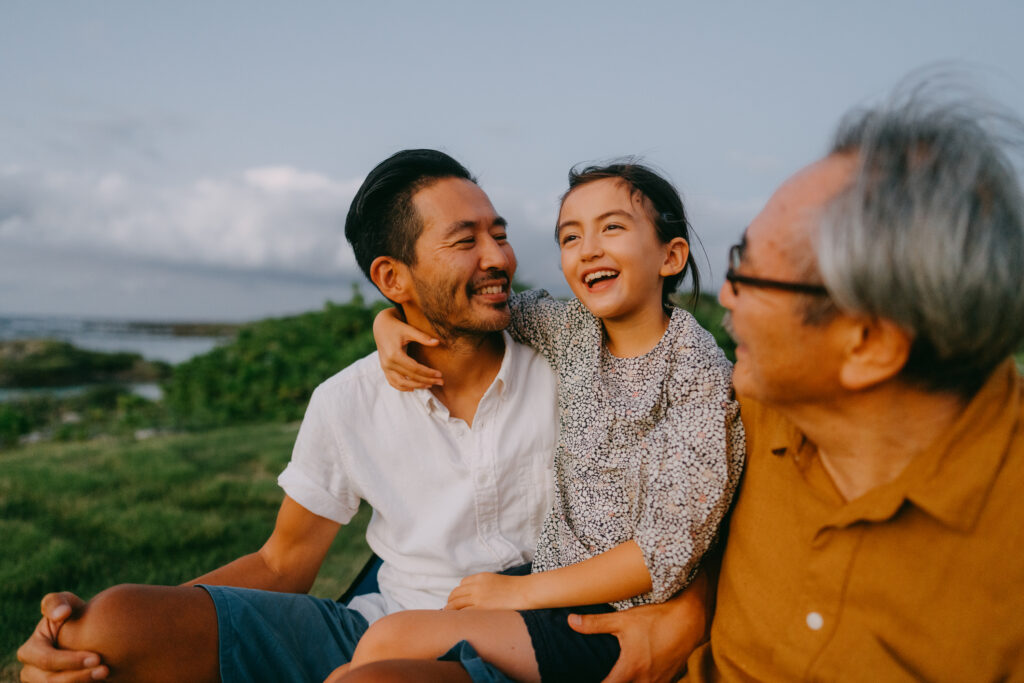 Man, child and older man sitting outside